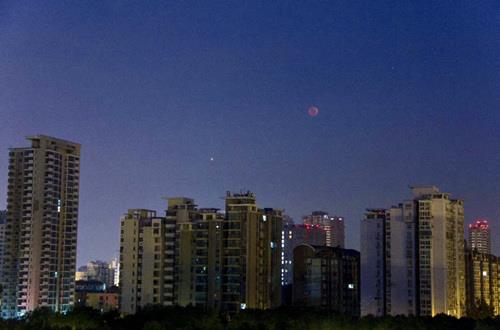 城市上空的红月亮和火星
